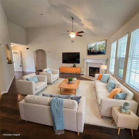 an empty room with wooden floor fan and windows