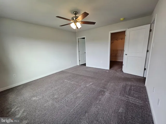 a view of an empty room with a chandelier fan