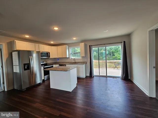 a kitchen with stainless steel appliances granite countertop a refrigerator microwave and stove top oven