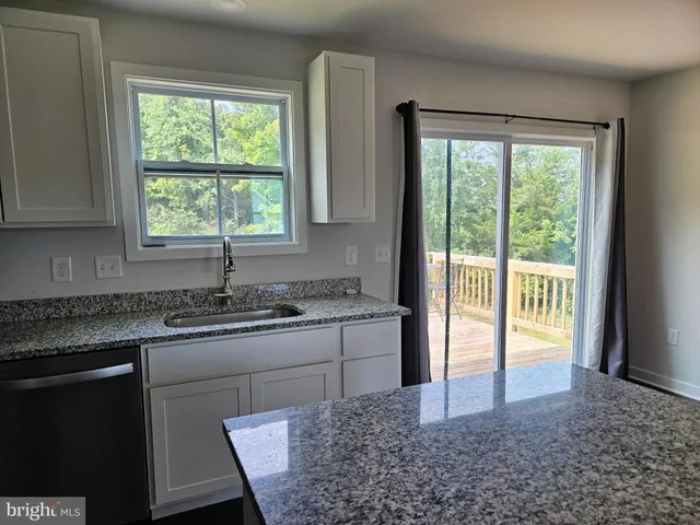 a kitchen with stainless steel appliances granite countertop sink stove and refrigerator
