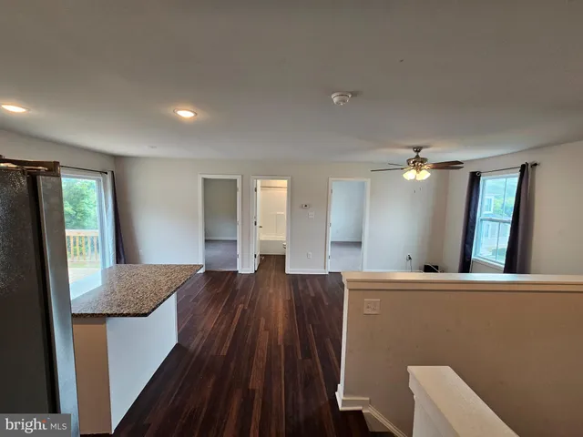 a view of hallway with furniture and wooden floor