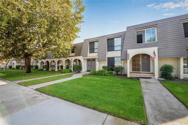 a front view of a house with garden and trees