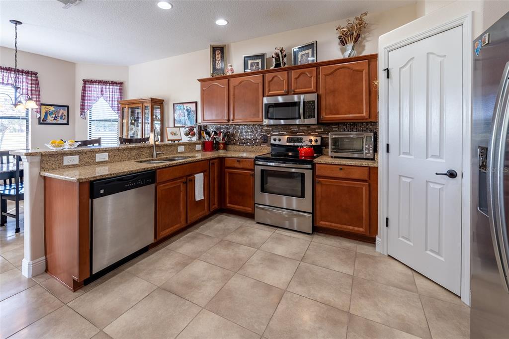 16222 Southwest 14th Avenue Road Ocala, FL 34473 - Photo 12 of 61 a kitchen with stainless steel appliances granite countertop a stove top oven a sink dishwasher and a refrigerator