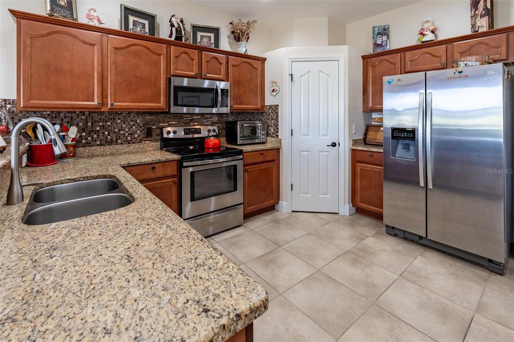 16222 Southwest 14th Avenue Road Ocala, FL 34473 - Photo 14 of 61 a kitchen with stainless steel appliances granite countertop a stove a sink and a refrigerator