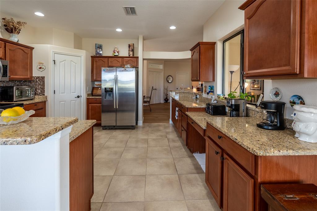 16222 Southwest 14th Avenue Road Ocala, FL 34473 - Photo 16 of 61 a kitchen with stainless steel appliances granite countertop a sink stove and refrigerator