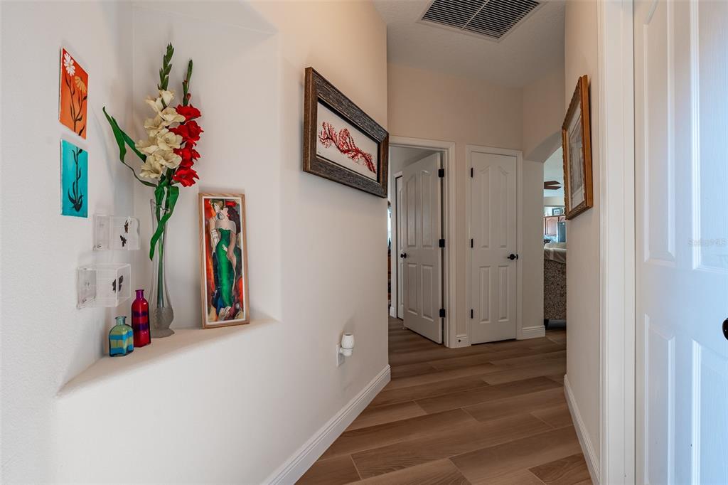 16222 Southwest 14th Avenue Road Ocala, FL 34473 - Photo 25 of 61 a view of a hallway with paintings on the wall and a potted plant