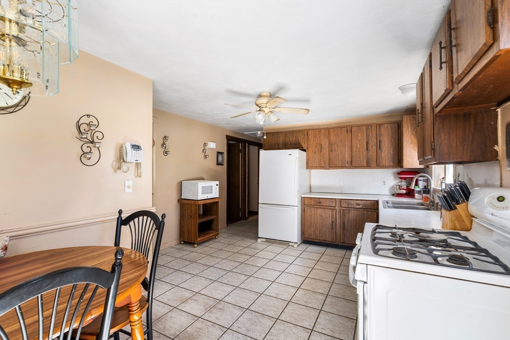 331 Grand Valley Road Springfield, MA 01128 - Photo 6 of 37 a kitchen with a stove a refrigerator and a dining table with wooden floor