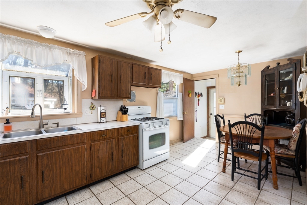 331 Grand Valley Road Springfield, MA 01128 - Photo 9 of 37 a kitchen with a sink stools a counter space and cabinets