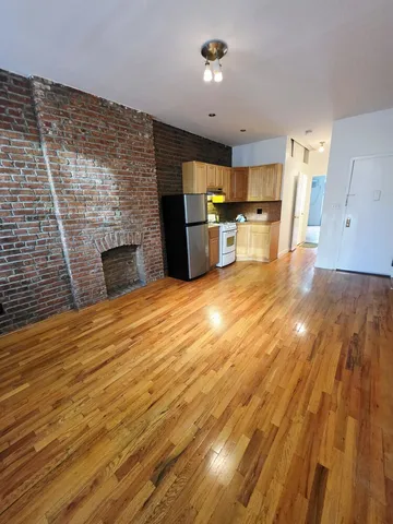 a view of empty room with wooden floor and fireplace