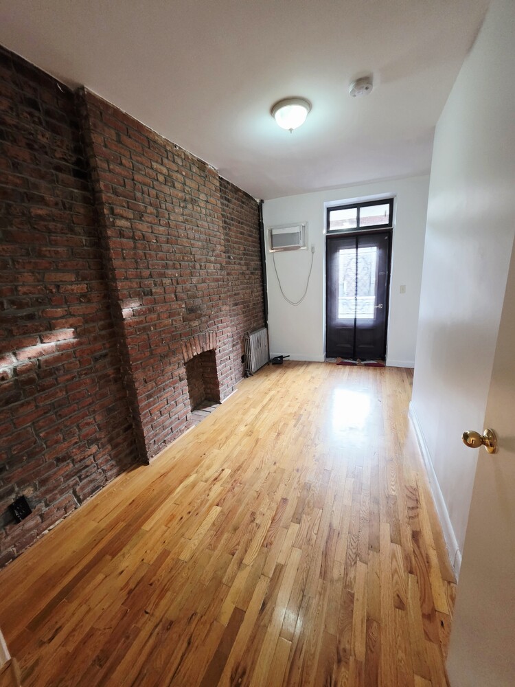 340 Atlantic Avenue, Unit 2L Brooklyn, NY 11201 - Photo 4 of 12 a view of empty room with wooden floor and fireplace