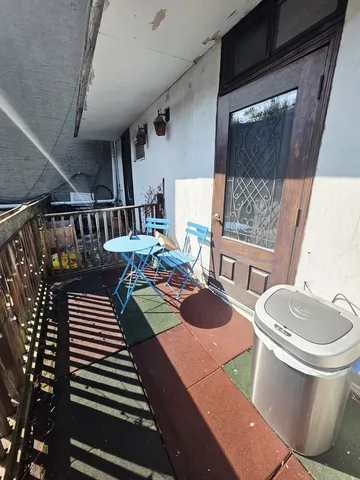 a balcony with chairs and a table