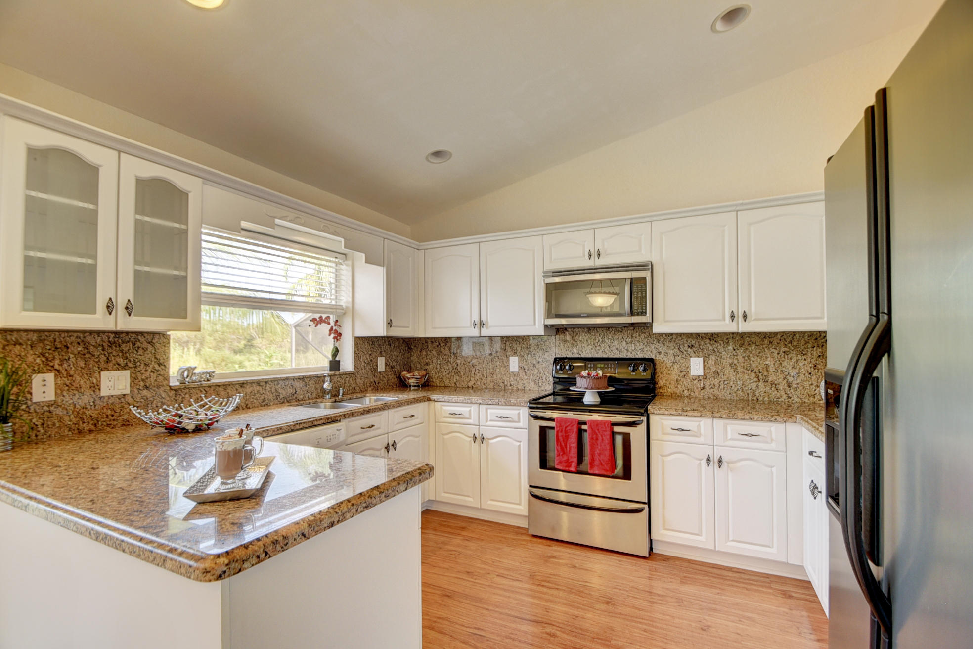 18098 Clear Brook Circle Boca Raton, FL 33498 - Photo 19 of 48 a kitchen with stainless steel appliances granite countertop a stove a sink and a refrigerator