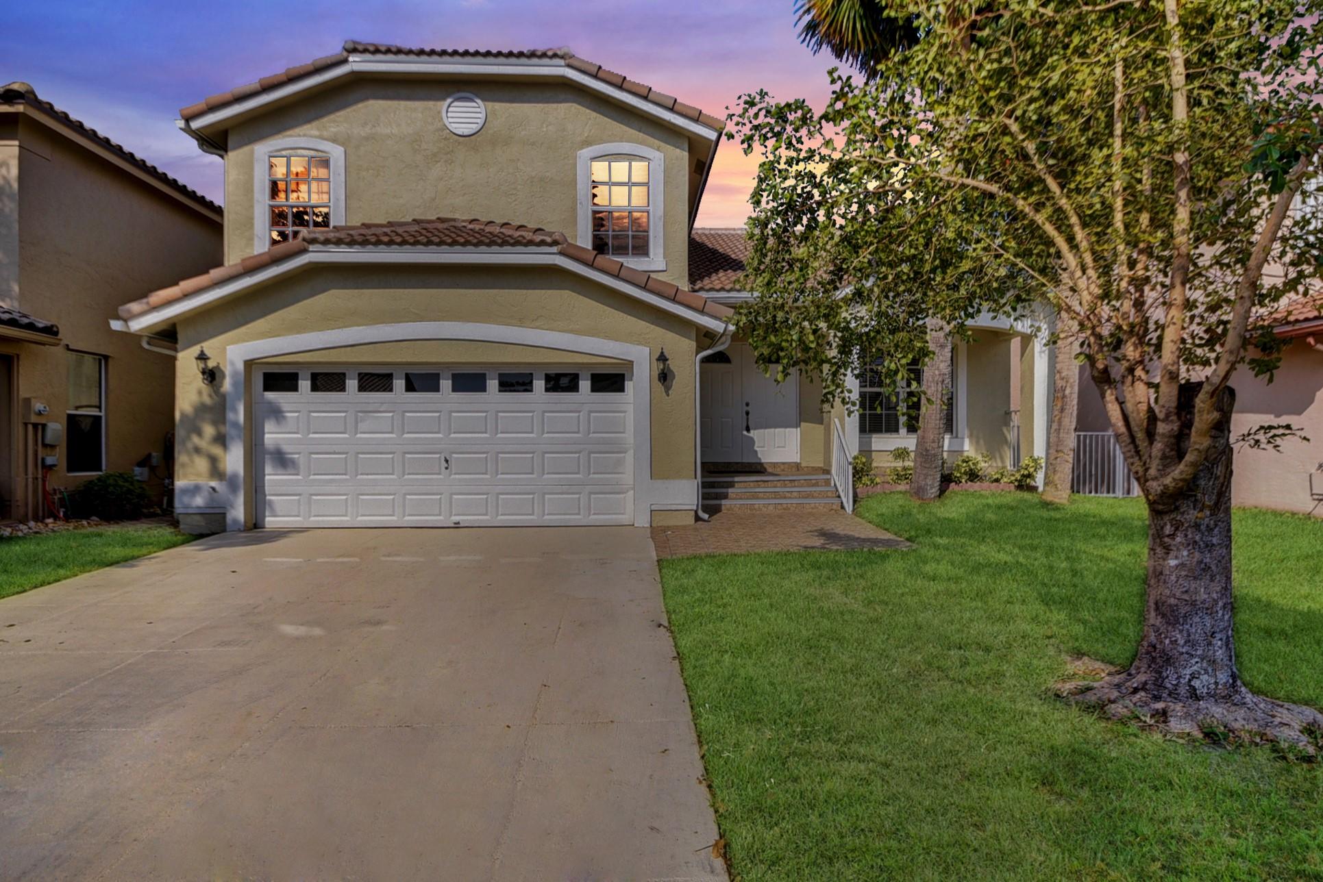 18098 Clear Brook Circle Boca Raton, FL 33498 - Photo 2 of 48 a front view of a house with a garden