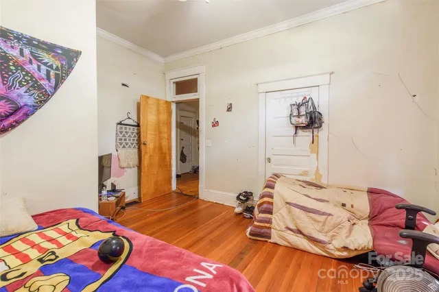 a bedroom with a bed and wooden floor