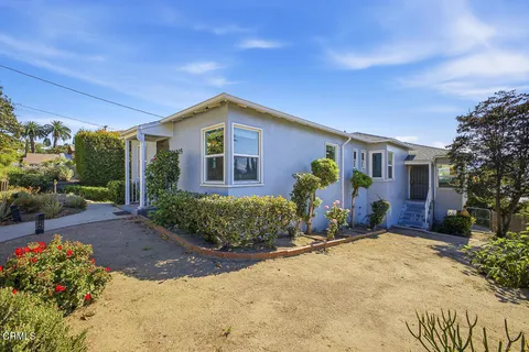 a front view of a house with a yard and outdoor seating