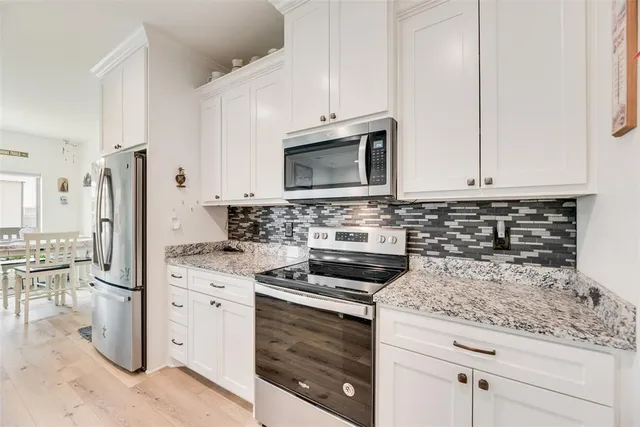 a kitchen with granite countertop a sink stove and refrigerator
