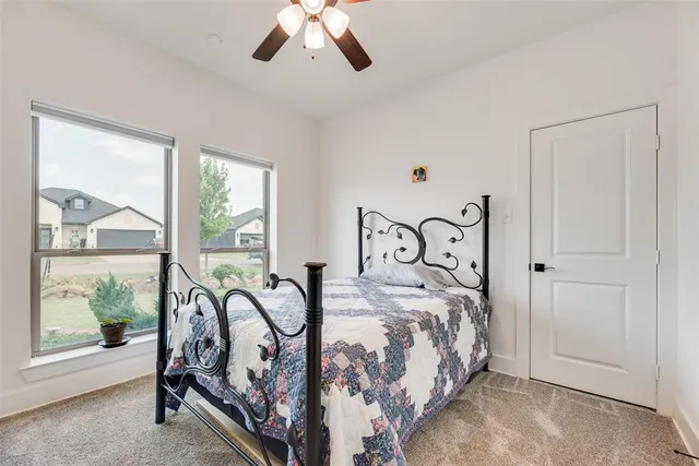 a bedroom with a bed and large windows