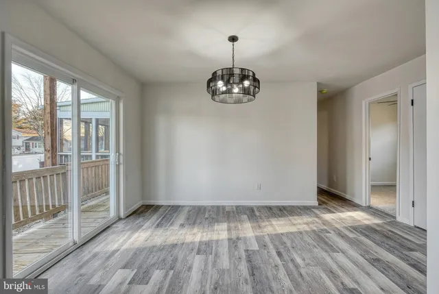 a kitchen with a refrigerator a sink and dishwasher a stove top oven with wooden floor