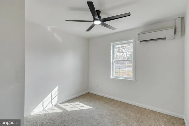 an empty room with a window and a fan
