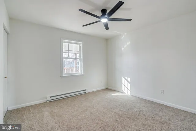 an empty room with a window and a fan