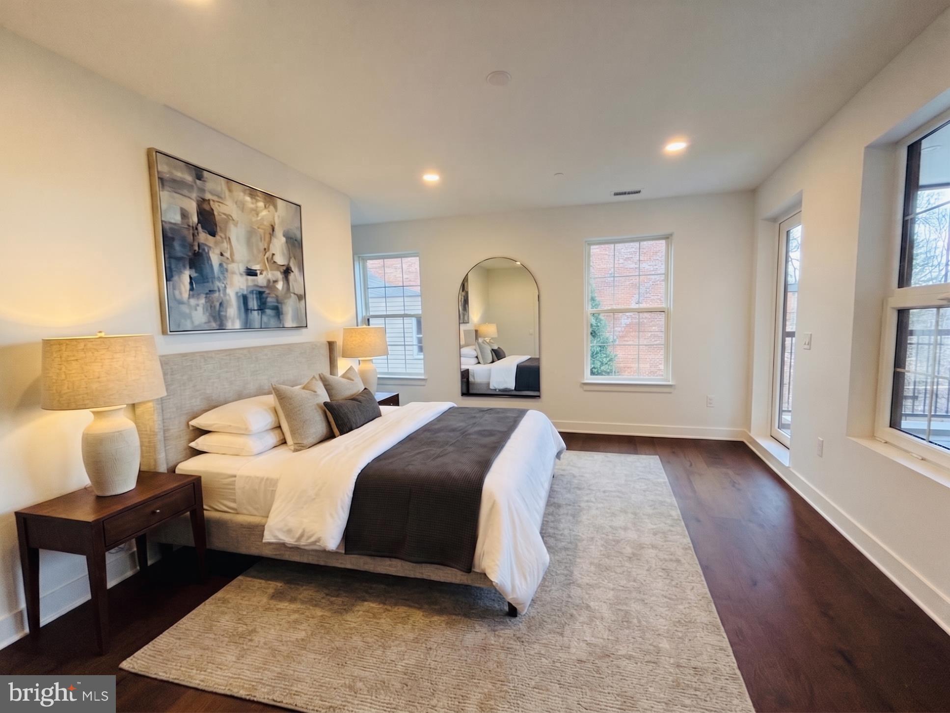 208 2nd Street East, Unit 202 Frederick, MD 21701 - Photo 7 of 9 a spacious bedroom with a bed painting on wall and a large window