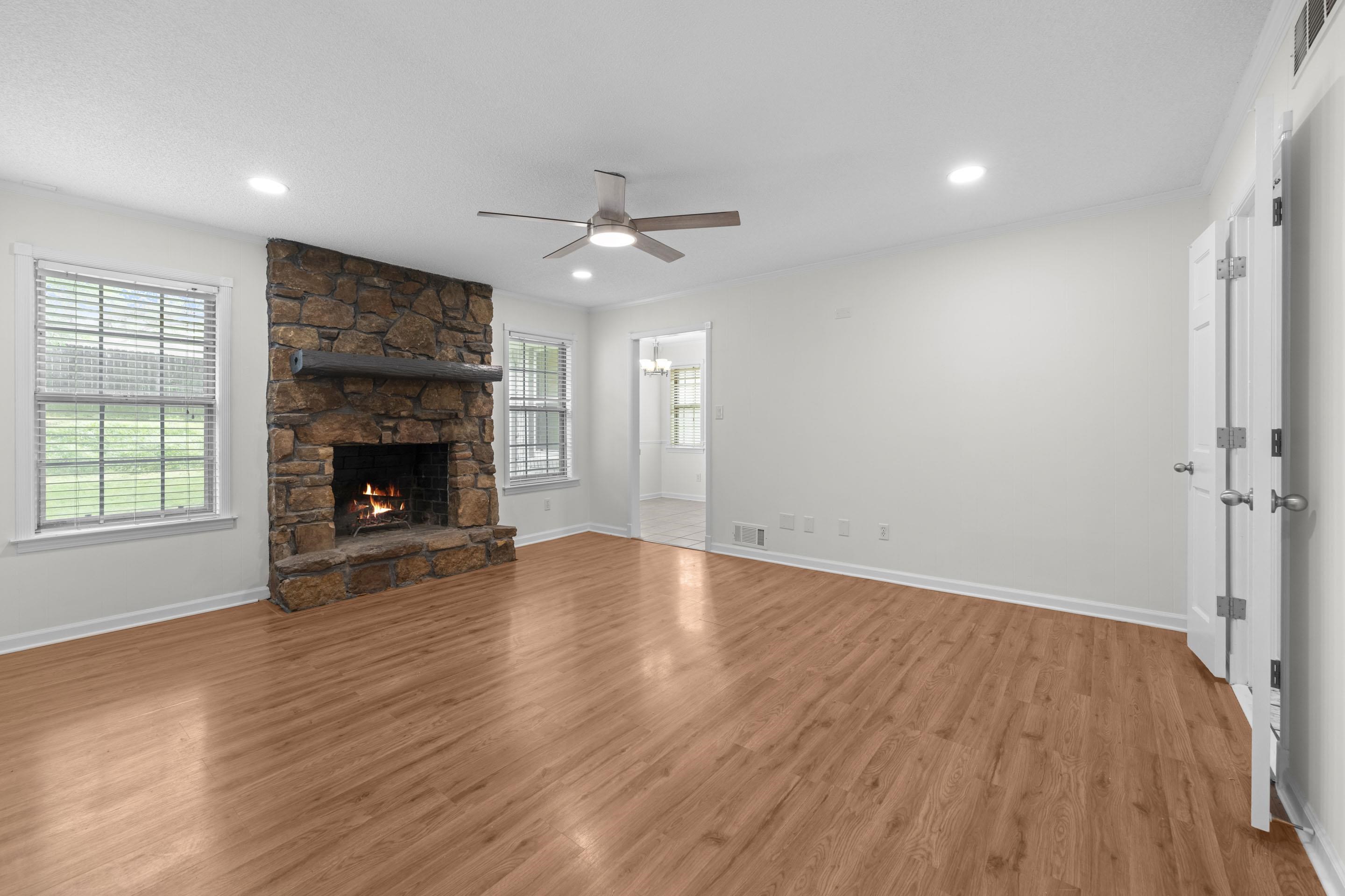 499 Duscoe Street Collierville, TN 38017 - Photo 6 of 38 an empty room with wooden floor fireplace cabinet and windows