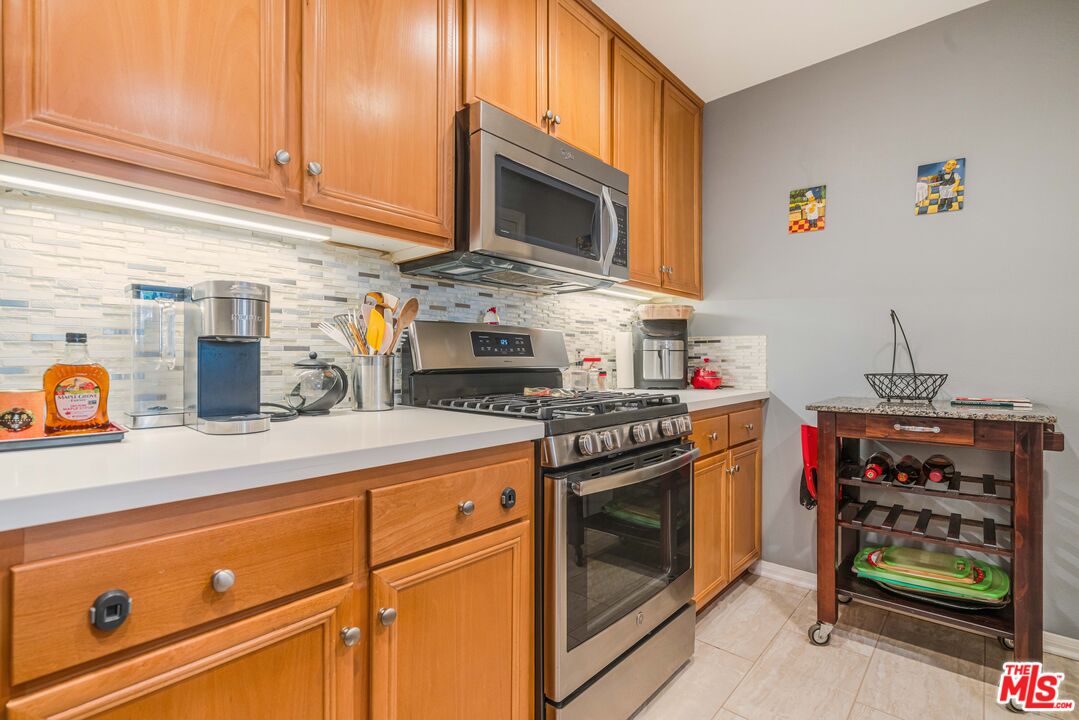 12963 West Runway Road, Unit 221 Playa Vista, CA 90094 - Photo 6 of 17 a kitchen with stainless steel appliances granite countertop a stove and a microwave