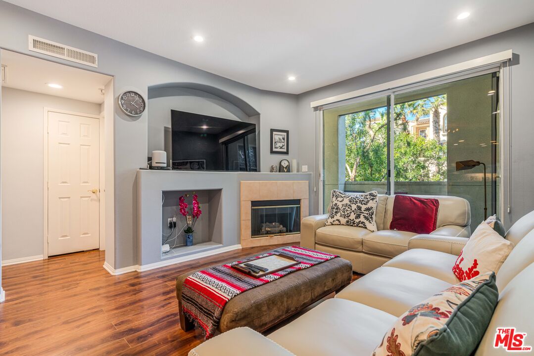 12963 West Runway Road, Unit 221 Playa Vista, CA 90094 - Photo 9 of 17 a living room with furniture a flat screen tv and a fireplace
