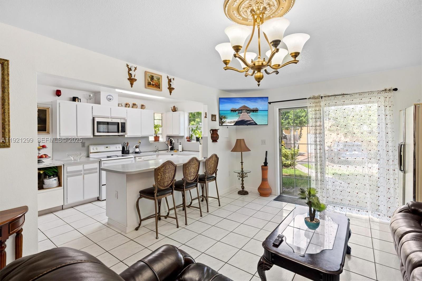 20851 Southwest 242nd Street Homestead, FL 33031 - Photo 11 of 42 a living room with furniture a chandelier and a dining table