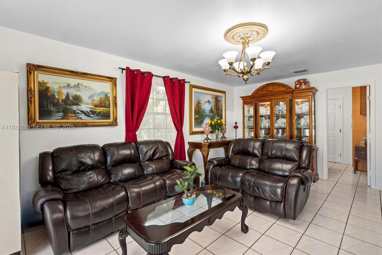 20851 Southwest 242nd Street Homestead, FL 33031 - Photo 14 of 42 a living room with furniture a chandelier and a window