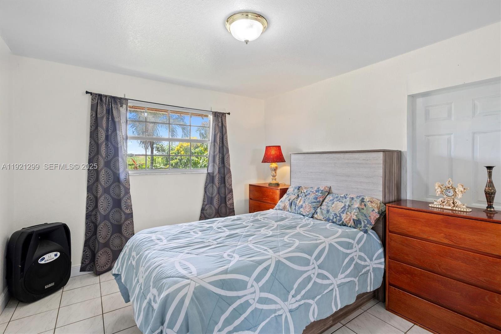 20851 Southwest 242nd Street Homestead, FL 33031 - Photo 23 of 42 a bedroom with a bed and a lamp on dresser
