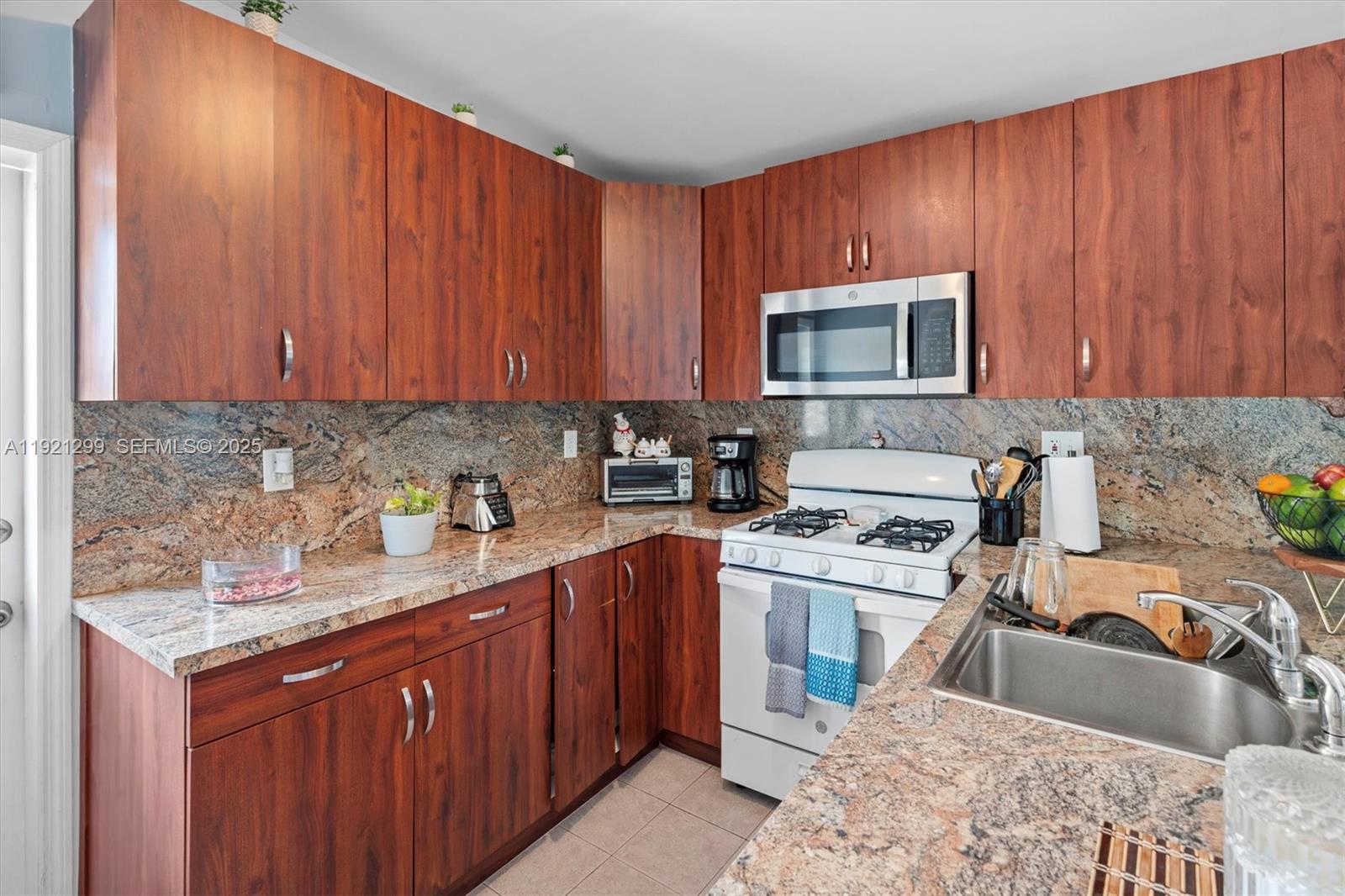 20851 Southwest 242nd Street Homestead, FL 33031 - Photo 29 of 42 a kitchen with stainless steel appliances granite countertop a sink stove and refrigerator