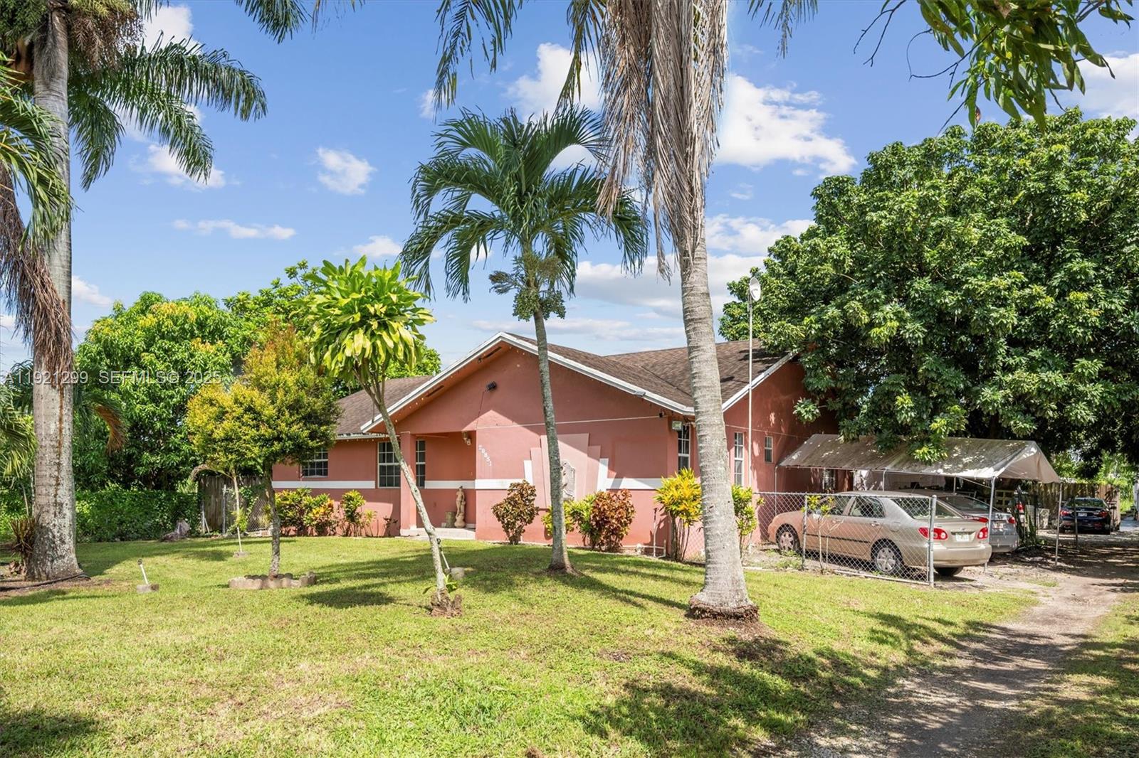 20851 Southwest 242nd Street Homestead, FL 33031 - Photo 3 of 42 a house that has a tree in front of it