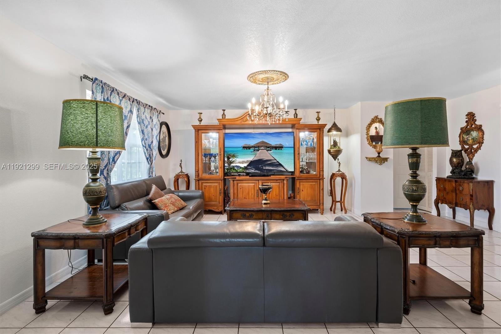 20851 Southwest 242nd Street Homestead, FL 33031 - Photo 6 of 42 a living room with furniture and a chandelier