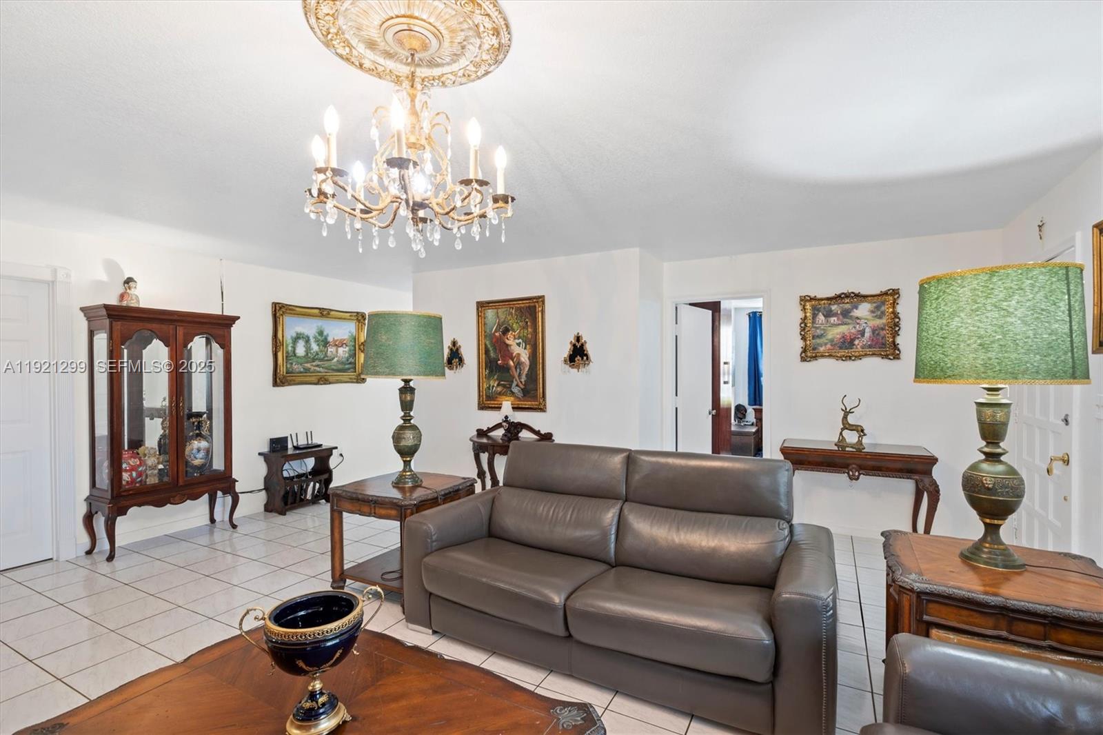 20851 Southwest 242nd Street Homestead, FL 33031 - Photo 8 of 42 a living room with furniture a chandelier a large window and a chandelier
