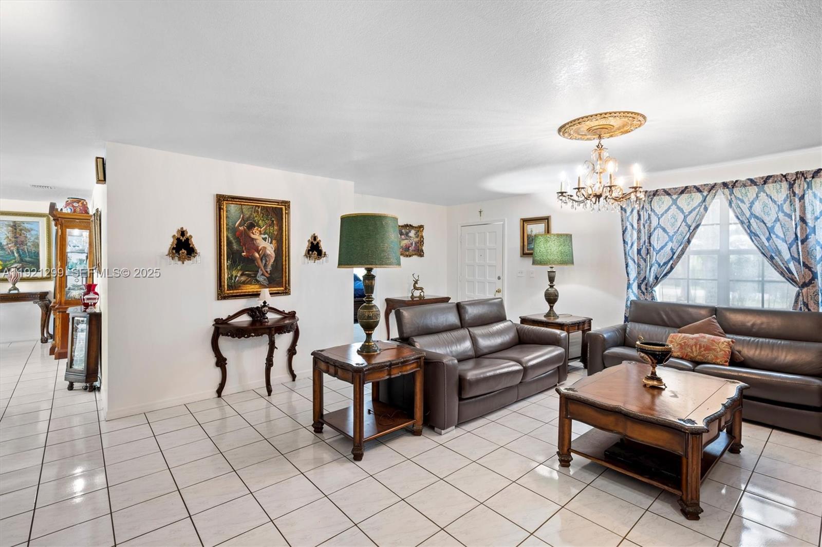 20851 Southwest 242nd Street Homestead, FL 33031 - Photo 9 of 42 a living room with furniture and a chandelier