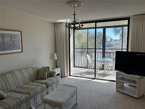 a living room with furniture a flat screen tv and a floor to ceiling window