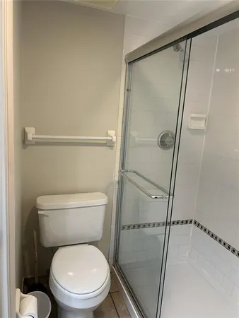 a white toilet sitting next to a shower