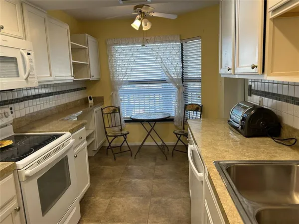 a kitchen with a stove and white cabinets