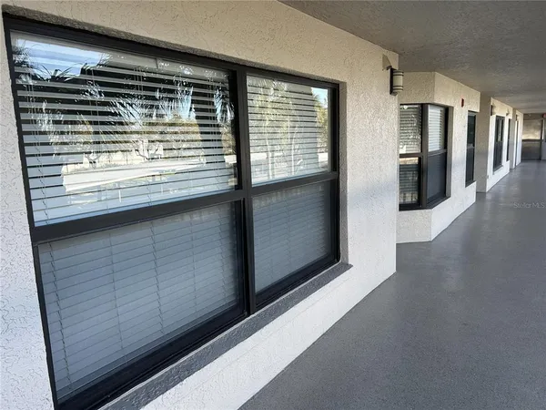 a view of kitchen with stainless steel appliances wooden floor and a window