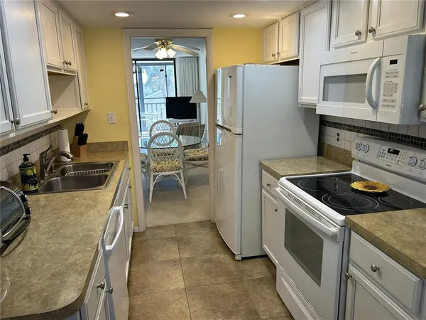 a kitchen with stainless steel appliances granite countertop a refrigerator stove microwave and sink