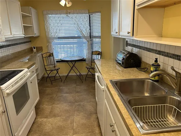 a kitchen with a sink a stove and cabinets