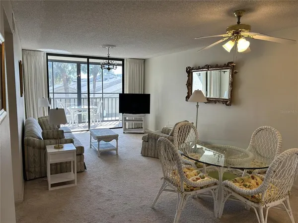 a dining room with furniture a flat screen tv and a large window