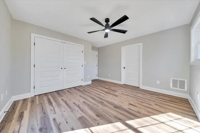 a view of empty room with wooden floor