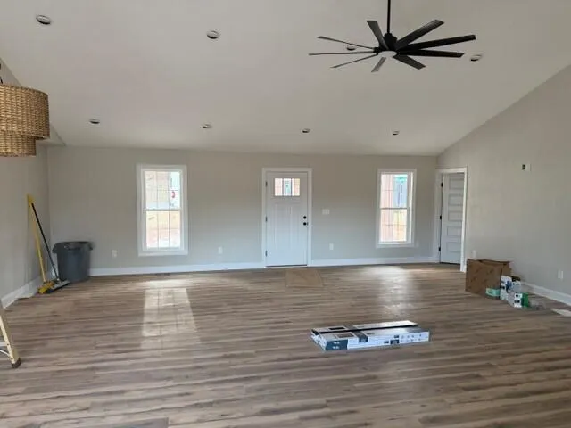 a view of empty room with window and wooden floor
