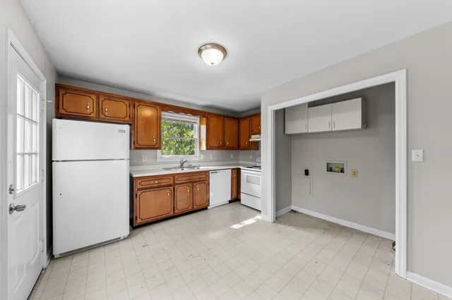 a kitchen with granite countertop a refrigerator and a sink