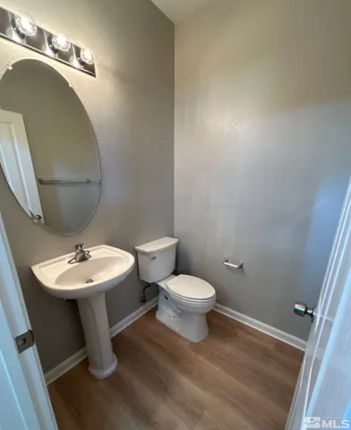 a bathroom with a toilet a sink and mirror