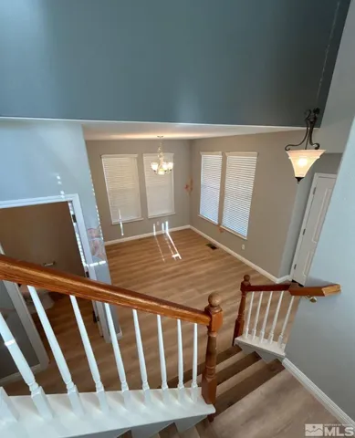 a view of staircase with railing and white walls