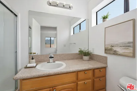 a bathroom with a granite countertop sink and a mirror