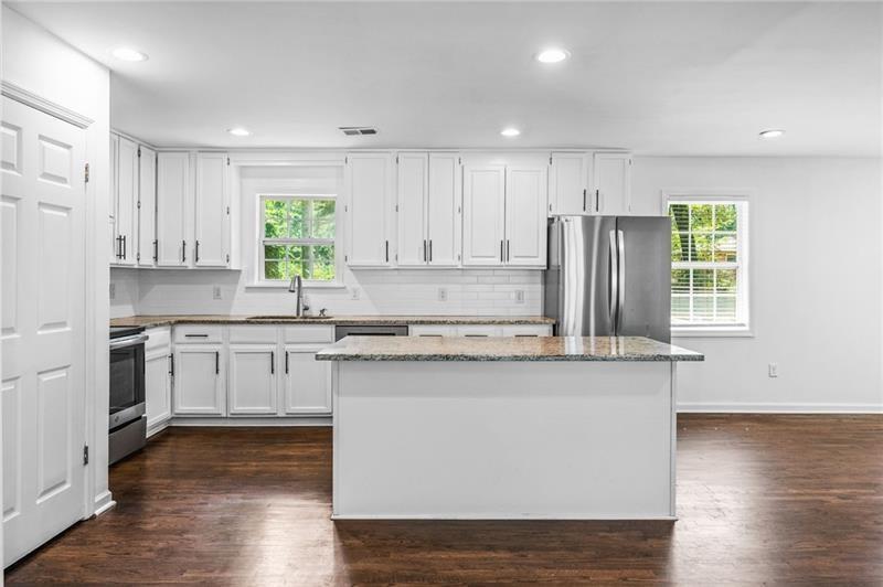 3089 Del Monico Drive Decatur, GA 30032 - Photo 12 of 47 a kitchen with stainless steel appliances granite countertop a stove a sink dishwasher and a refrigerator with wooden floor